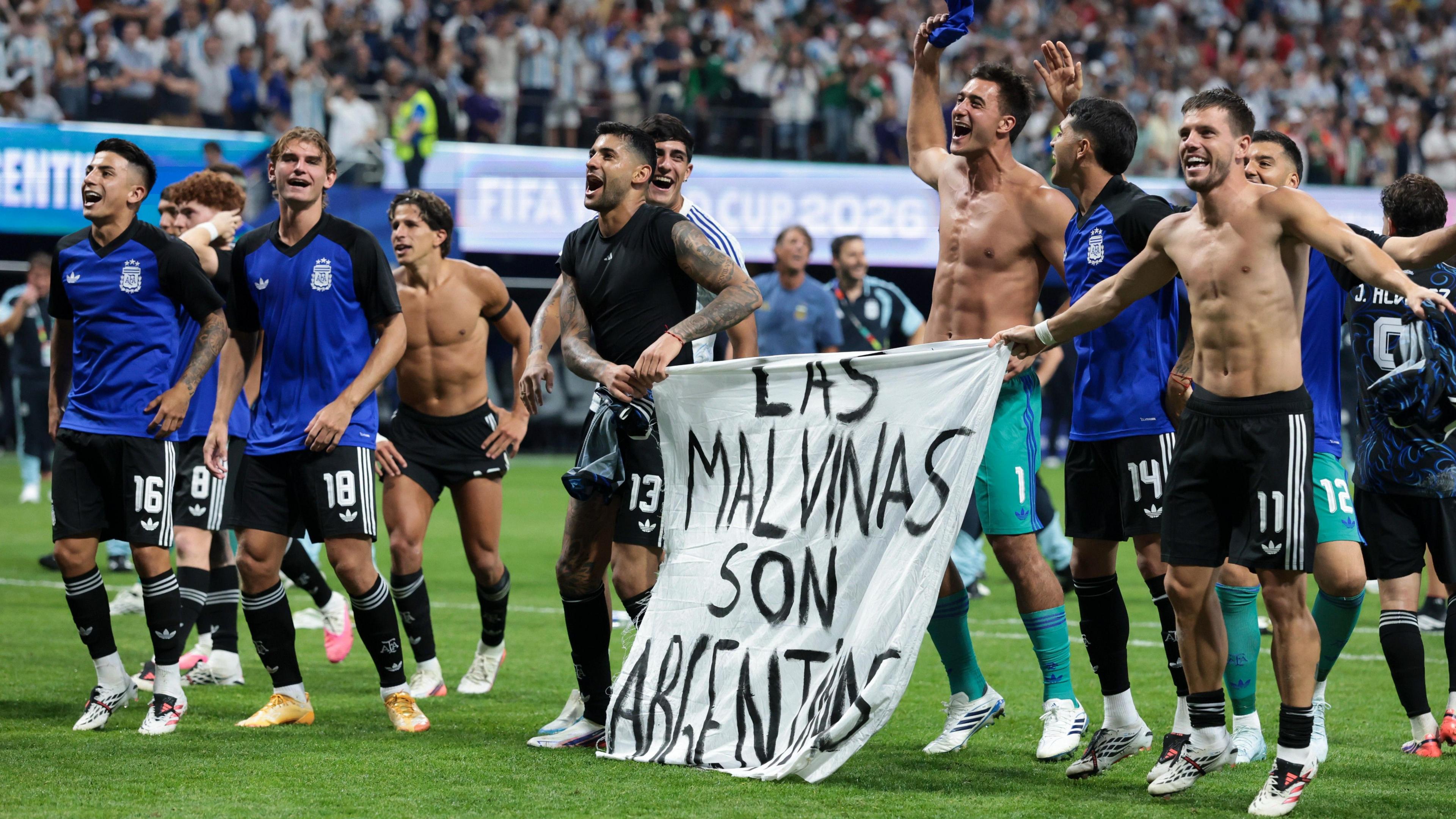 ผู้เล่นทีมชาติอาร์เจนตินาฉลองชัยชนะหลังจบเกม โดยถือแบนเนอร์ที่เขียนว่า