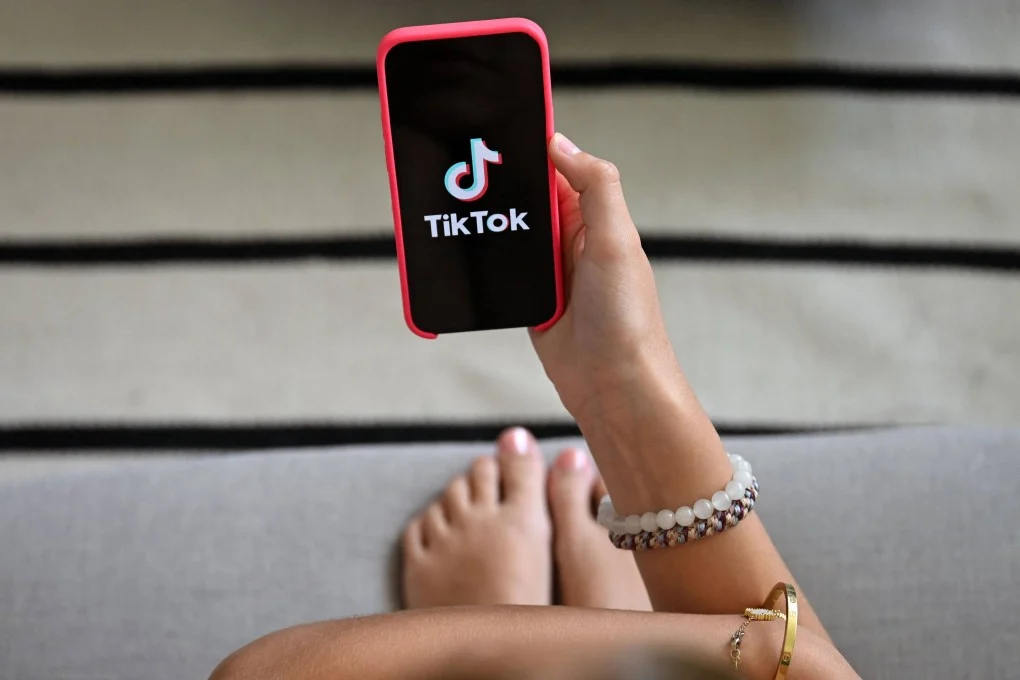 วัยรุ่นกำลังดูสมาร์ทโฟนที่แสดงโลโก้ TikTok ในกรุงบรัสเซลส์เมื่อวันที่ 7 กรกฎาคม