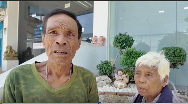 นายสมนึกยืนอยู่กับภรรยาของเขาที่ธนาคารกรุงไทย สาขาตากฟ้า จังหวัดนครสวรรค์ เขาใช้ความพยายามถึงห้าครั้งในการพิสูจน์ว่าเขาเป็นคนจน (ภาพ: ชลิต ภูมิรวางค์)