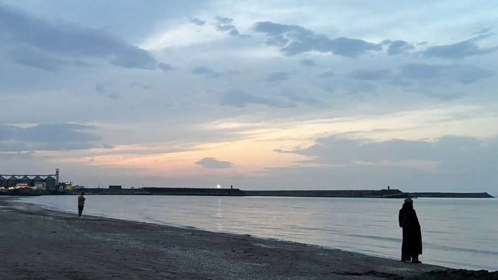 ผู้หญิงคนหนึ่งยืนอยู่บนชายหาดทะเลแคสเปียนในอิหร่าน ภาพจากไฟล์