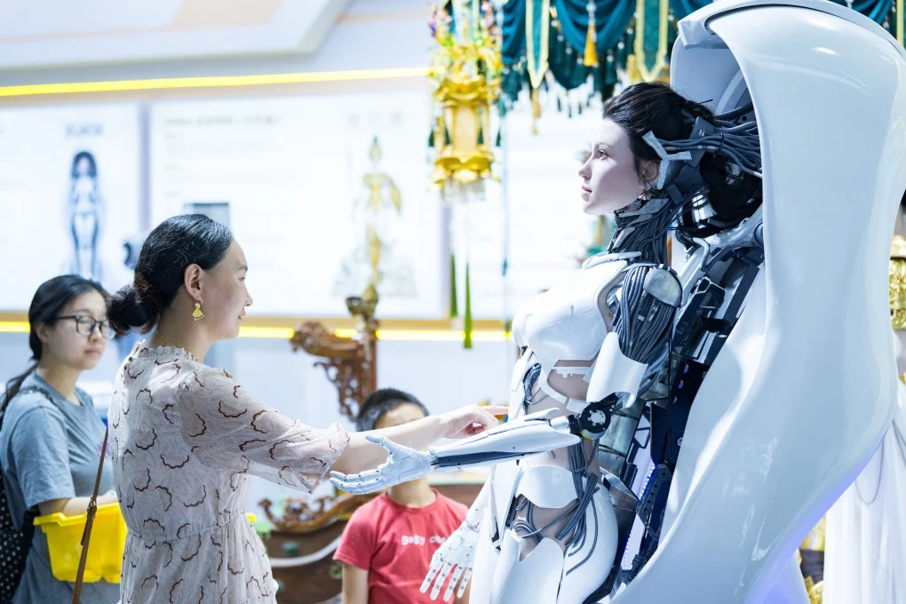 ผู้เยี่ยมชมงาน World Robot Conference ในกรุงปักกิ่งกำลังสัมผัสหุ่นยนต์ฮิวแมนนอยด์ที่จัดแสดงเมื่อวันที่ 19 สิงหาคม