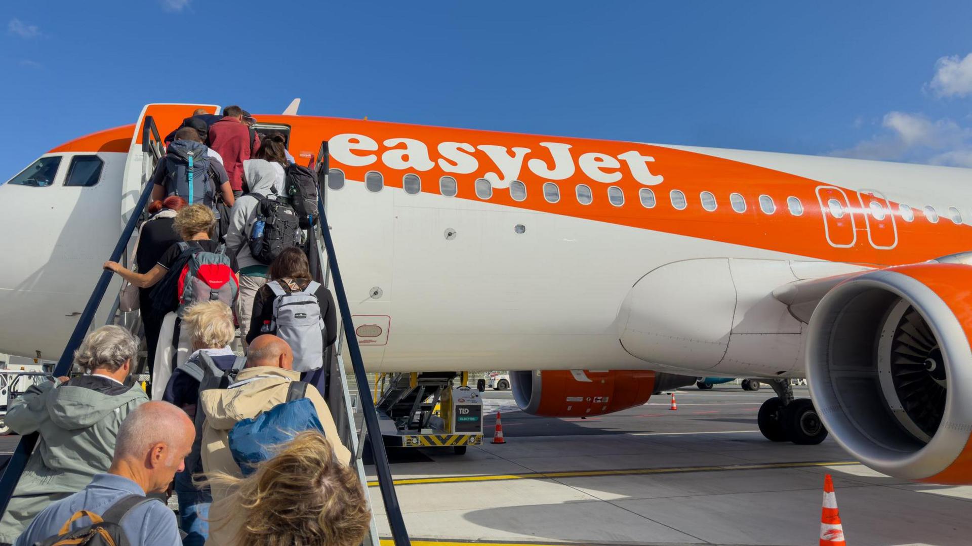 ผู้คนกำลังขึ้นเครื่องบิน EasyJet