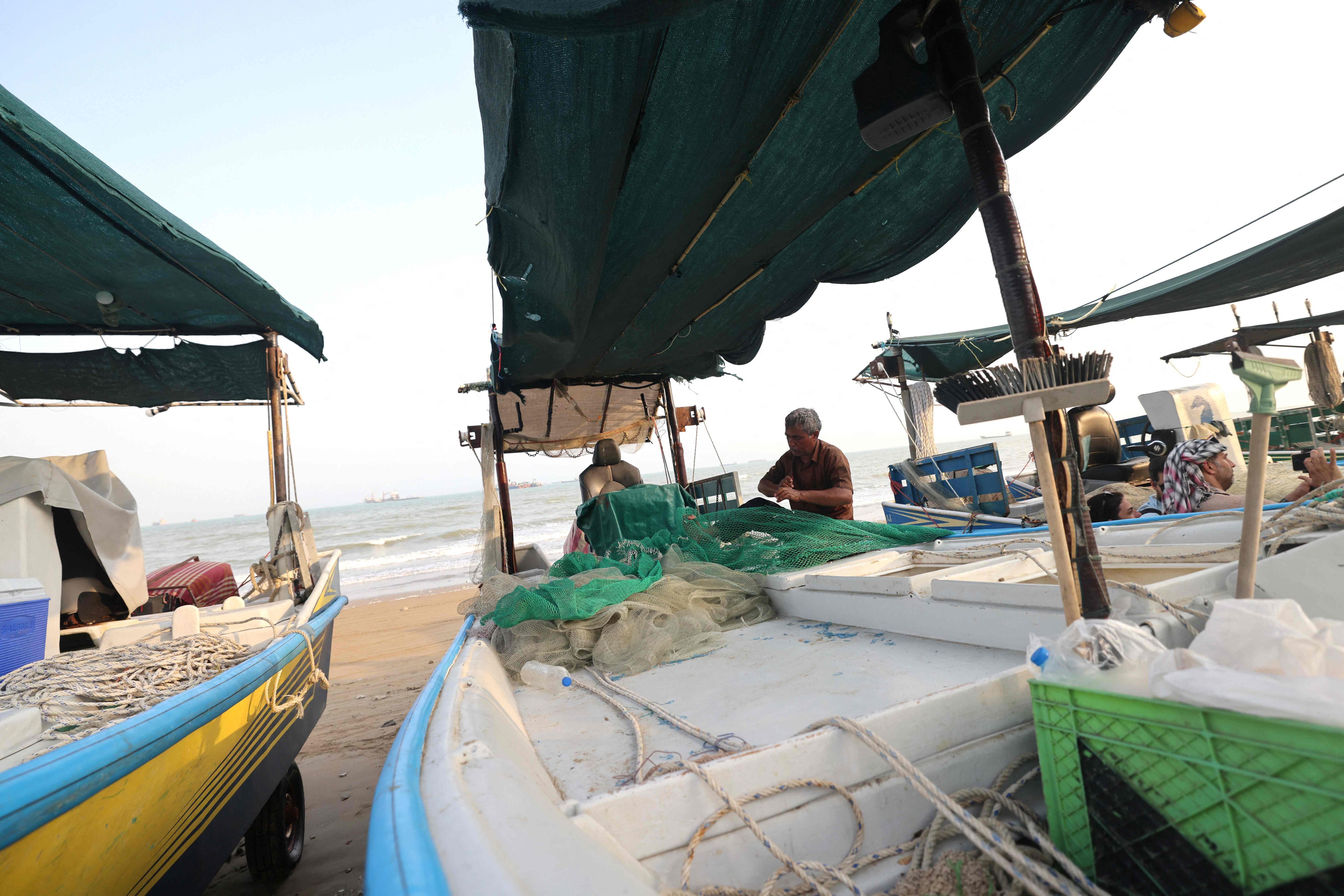 ชาวประมงตรวจดูตาข่ายและเรือเล็กของพวกเขาบริเวณชายฝั่งเมืองบันดาร์อับบาส ประเทศอิหร่าน เมื่อวันที่ 10 สิงหาคม