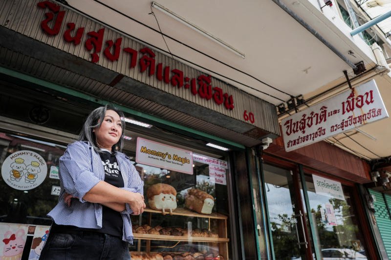 วรินธร บุญญชัย เจ้าของร้านสุชาติแอนด์เฟรนด์กันช็อป โพสท่าถ่ายรูปหน้าร้านในย่านร้านปืนเก่าแก่ของกรุงเทพฯ วังบูรพา เมื่อวันศุกร์ (ภาพ: รอยเตอร์)