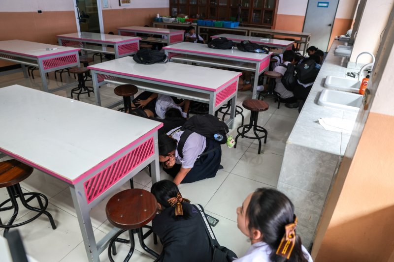 นักเรียนหมอบใต้โต๊ะระหว่างการฝึกซ้อมรับมือเหตุกราดยิง ที่โรงเรียนสุรศักดิ์มนตรี กรุงเทพฯ วันที่ 19 ส.ค. 2026 (ภาพ: Reuters)