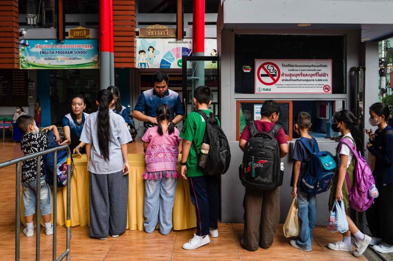 เจ้าหน้าที่ตรวจสอบกระเป๋านักเรียนตามมาตรการรักษาความปลอดภัยใหม่ ขณะที่นักเรียนเดินทางมาถึงโรงเรียนสวัสดีวิทยา กรุงเทพฯ เมื่อวันศุกร์ นักเรียนหลายสิบคนเข้าคิวที่โรงเรียนในกรุงเทพฯ ยื่นกระเป๋าให้คุณครูตรวจค้นเพื่อความปลอดภัย หนึ่งสัปดาห์หลังเกิดเหตุกราดยิงที่ร้ายแรง ซึ่งเป็นหนึ่งในเหตุการณ์ที่เลวร้ายที่สุดในประเทศไทยช่วงไม่กี่ปีที่ผ่านมา (ภาพ: เอเอฟพี)