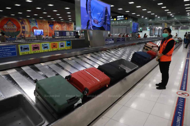 พนักงานสนามบินเฝ้าดูกระเป๋าเดินทางบนสายพานที่สนามบินสุวรรณภูมิ จังหวัดสมุทรปราการ (ภาพไฟล์: สมชัย ภูมิลาร์ด)