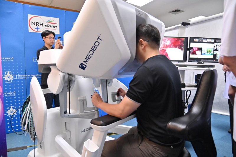 แพทย์โรงพยาบาลนพรัตนราชธานีในกรุงเทพฯ กำลังทำการผ่าตัดด้วยหุ่นยนต์ทางไกลสำหรับผู้ป่วยมะเร็งต่อมลูกหมากที่โรงพยาบาลมหาราชนครราชสีมา ซึ่งอยู่ห่างออกไปกว่า 250 กิโลเมตร นับเป็นครั้งแรกของไทย