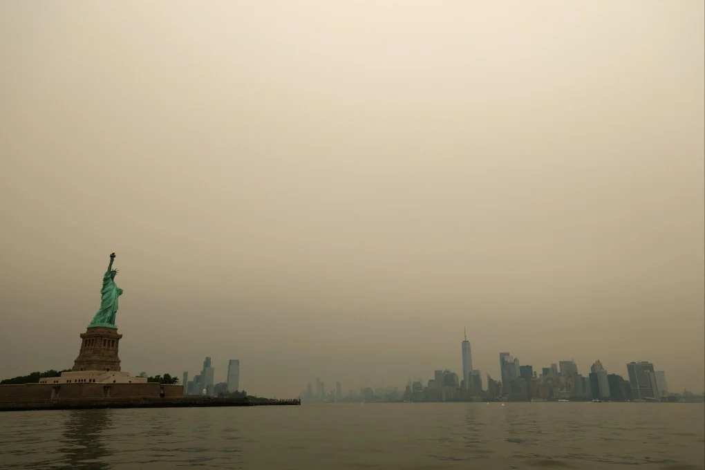 เทพีเสรีภาพและเส้นขอบฟ้าเมืองนิวยอร์กที่มองเห็นผ่านควันไฟป่าจากอ่าว New York เมื่อวันที่ 16 กรกฎาคม ภาพ: รอยเตอร์ส