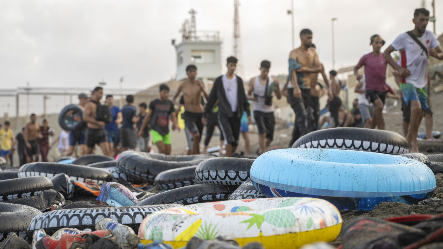 ลูกยางเป่าลมจำนวนมากวางอยู่บนชายหาดในเซวตา โดยมีผู้อพยพอยู่เบื้องหลัง - กรกฎาคม 2026
