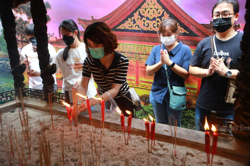 ประชาชนกำลังทำบุญด้วยธูปและเทียน ณ วัดพุทธในกรุงเทพฯ (ภาพ: สมชัย พุ่มหลาด)