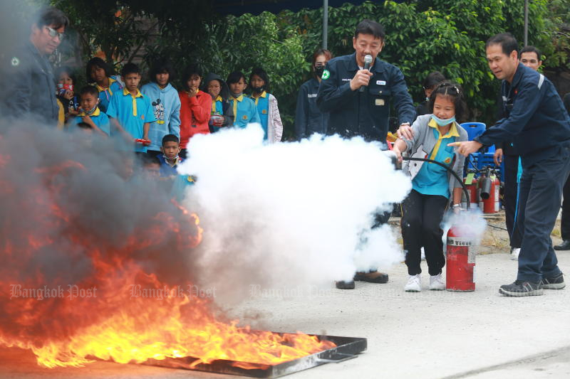 อาสาสมัครกู้ภัยกำลังสอนนักเรียนใช้ถังดับเพลิงที่โรงเรียนในจังหวัดสมุทรปราการ (ภาพ: สมชัย พุ่มหลาด)