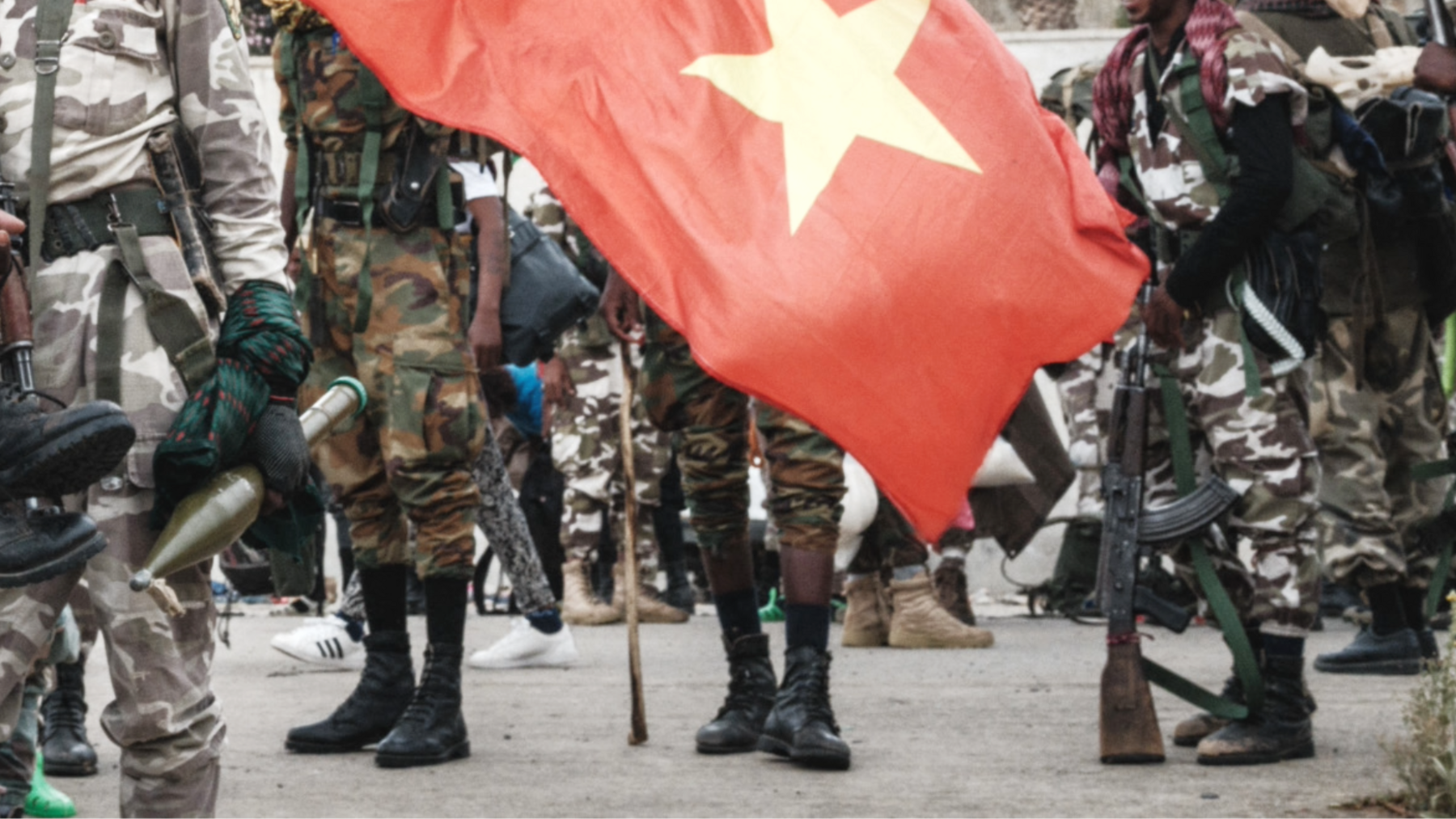 ภาพทหาร TPLF ด้านหลังธงทิเกรย์ ซึ่งมีพื้นหลังสีแดงและดาวสีเหลือง (ภาพเก่า)