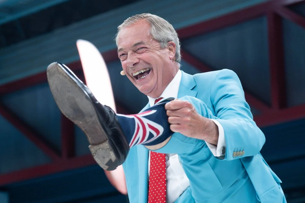 Nigel Farage ผู้นำพรรค Reform UK สวมถุงเท้าของเขาในระหว่างการประชุม Reform UK National Conference ที่ National Exhibition Centre ในเบอร์มิงแฮม เมื่อวันที่ 5 กันยายน