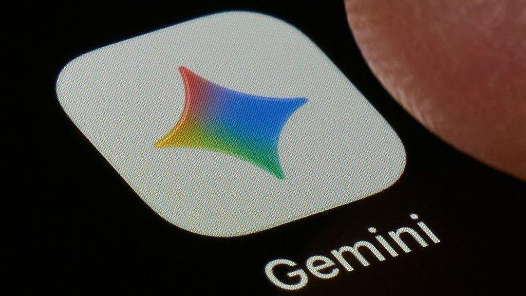 ภาพระยะใกล้ของแอปพลิเคชัน Gemini บนหน้าจอสีดำ ไอคอนเป็นสี่เหลี่ยมสีขาวมีดาวสี่แฉกในสีของ Google โดยมีคำว่า 'Gemini' พิมพ์อยู่ด้านล่าง