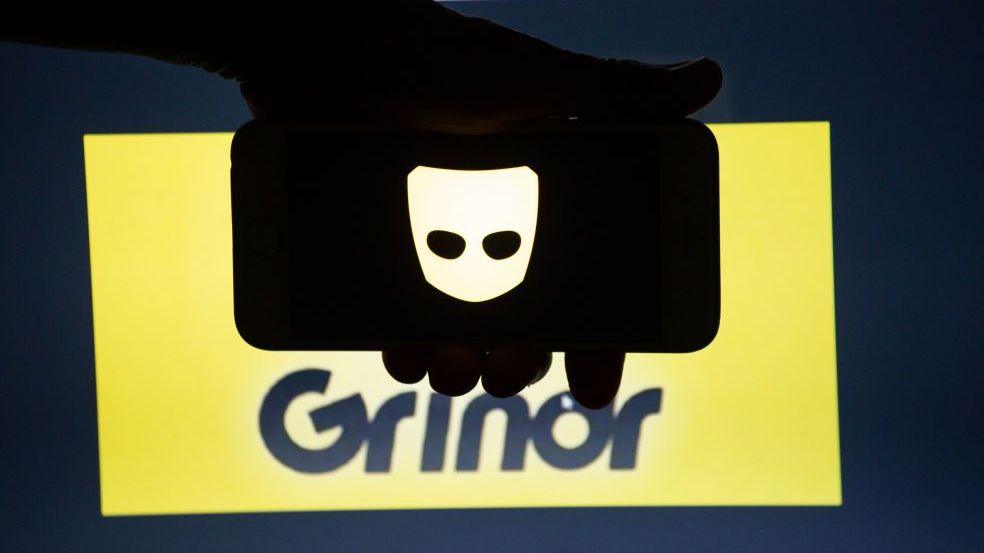 โลโก้แอป Grindr แสดงอยู่บนหน้าจอสมาร์ทโฟน โดยมีฉากหลังสีเหลืองและดำพร้อมโลโก้ของบริษัท