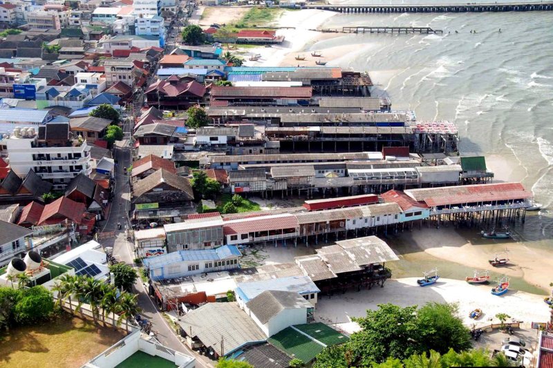 ภาพมุมสูงแสดงสิ่งปลูกสร้างบริเวณชายหาดหัวหิน ระหว่างท่าเทียบเรือประมงและศาลเจ้าแม่ทับทิม ศาลปกครองสูงสุดมีคำวินิจฉัยเมื่อปี 2557 ว่าสิ่งปลูกสร้างเหล่านี้รุกล้ำ แต่การต่อสู้ทางกฎหมายเพื่อชะลอการรื้อถอนได้ยืดเยื้อมานานหลายปี (ภาพ: ชัยวัฒน์ สัตยาเอม)