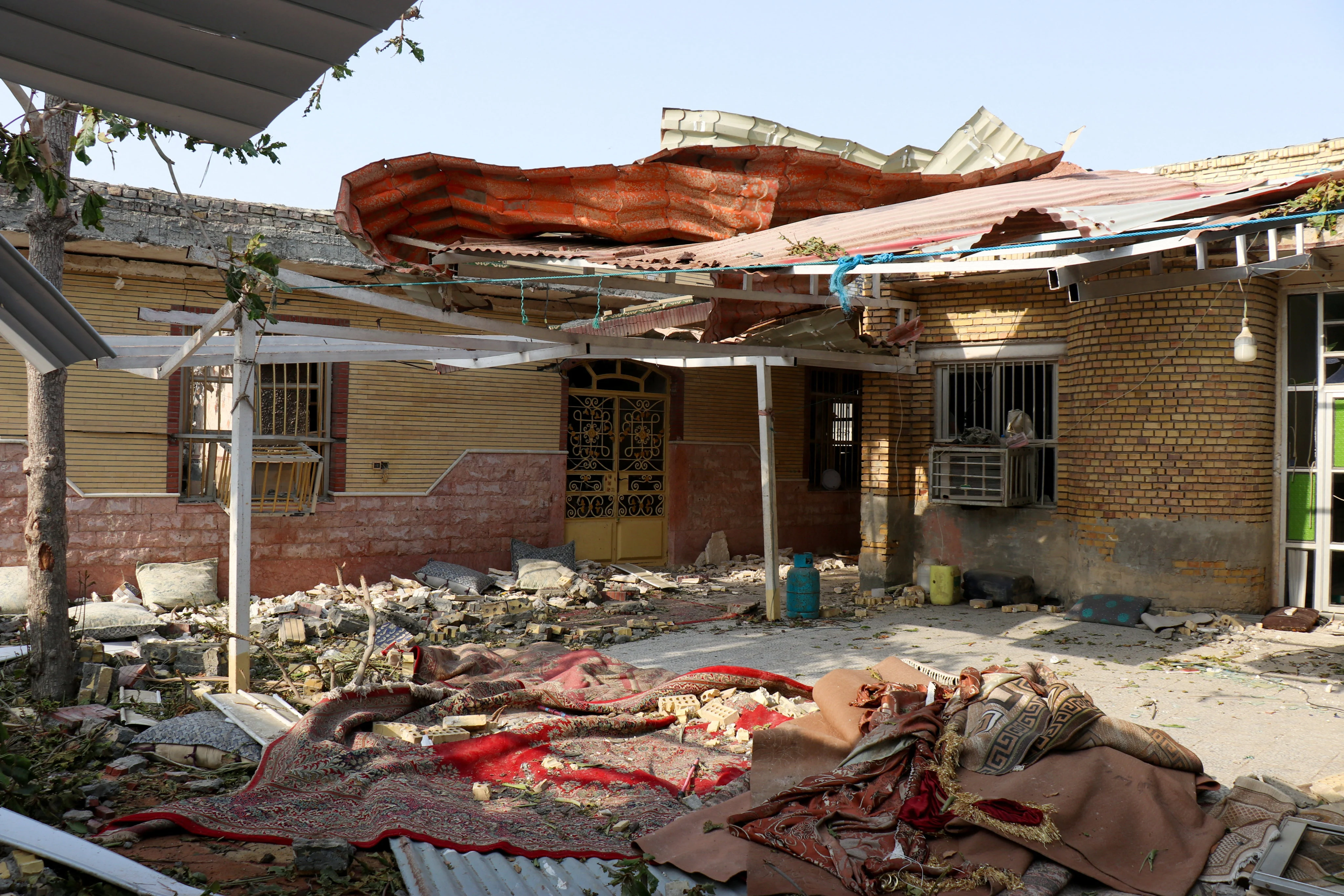 เศษซากปรักหักพังกองอยู่รอบๆ บ้านที่เสียหาย ภาพ: สำนักข่าว West Asia News Agency ผ่าน Reuters