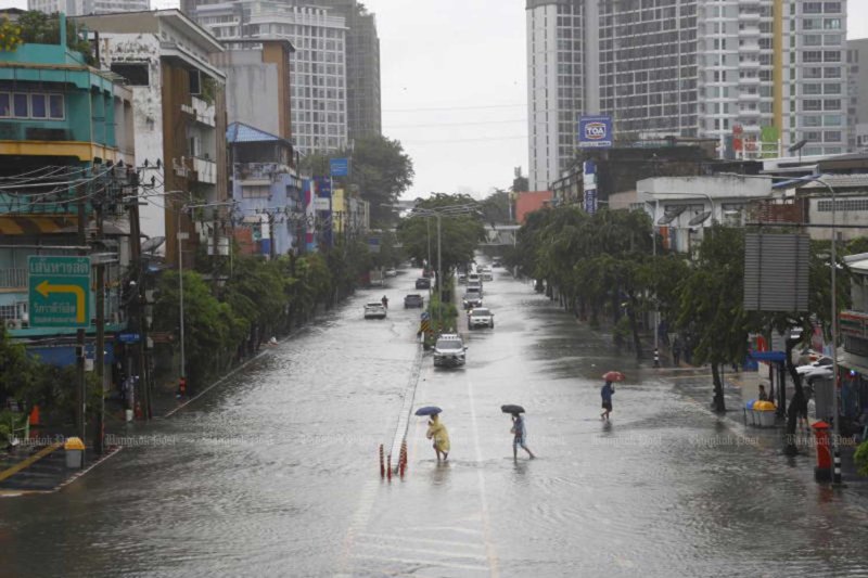 ภาพ: ประชาชนเดินข้ามถนนลาดพร้าวท่ามกลางสายฝนในกรุงเทพฯ เมื่อวันเสาร์ (ภาพ: ณัฐวัฒน์ วิเชียรบุตร)