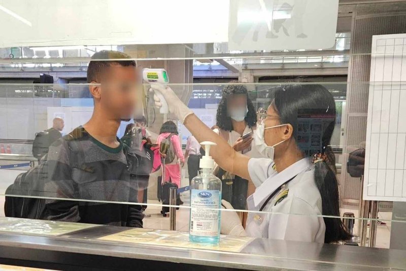 เจ้าหน้าที่ควบคุมโรคกำลังวัดอุณหภูมิร่างกายผู้เดินทางที่สนามบินเพื่อป้องกันการแพร่ระบาดของโรคฝีดาษวานรในประเทศไทย (ภาพถ่ายไฟล์: กรมควบคุมโรค)