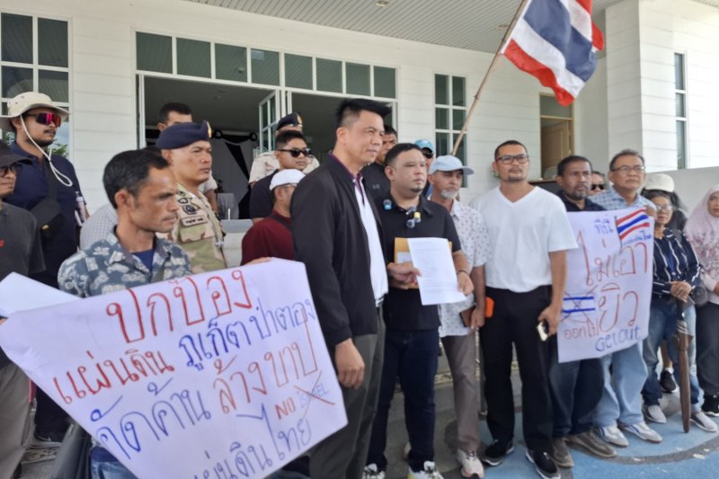 สายชล หนูเช็ต (กลาง) แกนนำกลุ่มปกป้องแผ่นดินภูเก็ต ยื่นหนังสือขอให้ระงับการจัดงานฉลองปีใหม่ยิวที่กำหนดจัดขึ้นในสุดสัปดาห์นี้ต่อ นายศิวะ วัชระพงษ์กุล นายอำเภอเมืองภูเก็ต ณ ศาลากลางจังหวัดภูเก็ต เมื่อวันอังคาร (ภาพ: อาชัททยา ชื่นนิรันดร์)