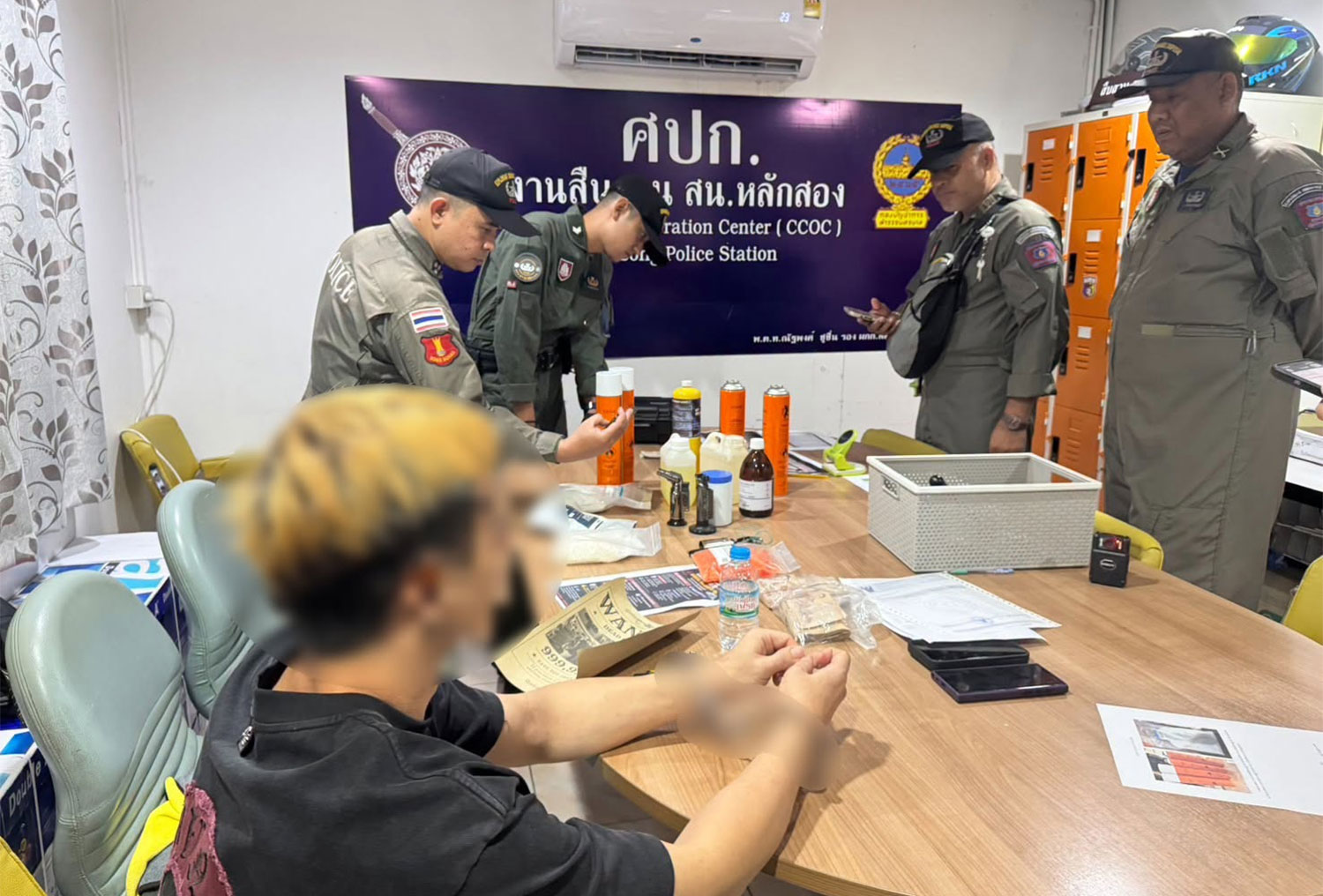 ผู้ต้องสงสัยชาวสิงคโปร์ถูกนำตัวมายังสถานีตำรวจหลักสอง หลังจากตำรวจจับกุมเขาได้ที่คอนโดมิเนียมในกรุงเทพฯ