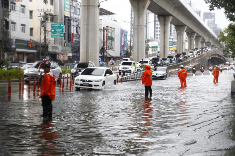 ตำรวจจัดการจราจรบนถนนที่น้ำท่วมในเขตบางเขน กรุงเทพฯ หลังฝนตกหนักต่อเนื่องเมื่อวันศุกร์ (ภาพ: ณัฐวัฒน์ วิเชียรบุตร)