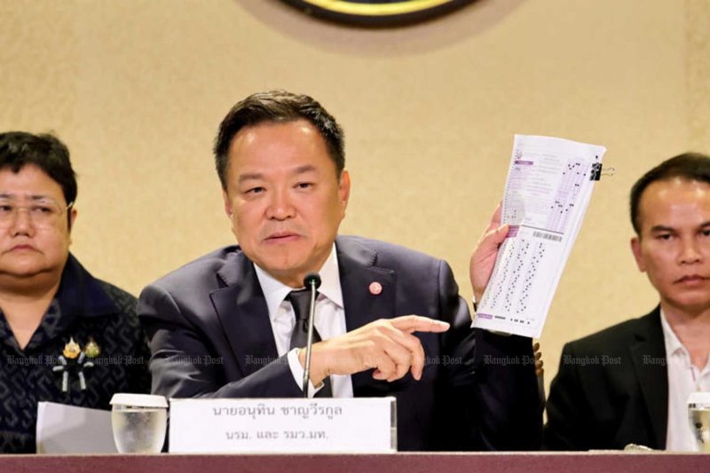 นายกรัฐมนตรีอนุทิน ชาญวีรกูล แสดงกระดาษคำตอบที่ทำเนียบรัฐบาลเมื่อต้นเดือนกรกฎาคม ระหว่างการบรรยายสรุปเรื่องการทุจริตในการสอบเข้ารับราชการส่วนท้องถิ่น ชนัต คตัญญู