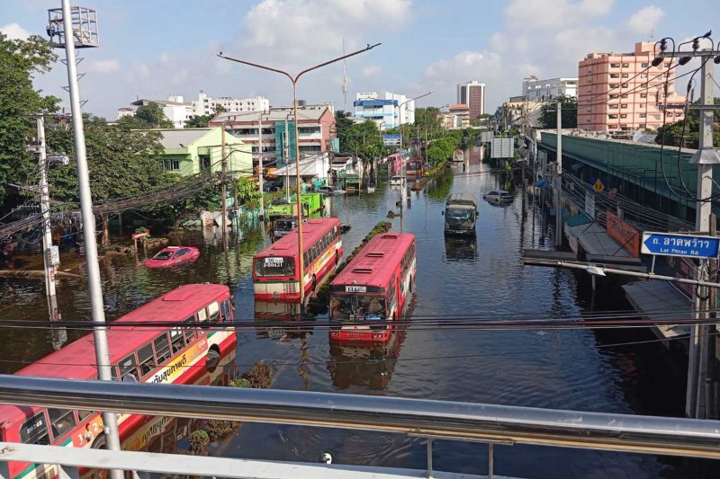 รถโดยสารและรถบรรทุกกำลังวิ่งบนถนนนวมินทร์ที่น้ำท่วมขัง ในเขตบางกะปิ กรุงเทพฯ เมื่อเช้าวันพุธ