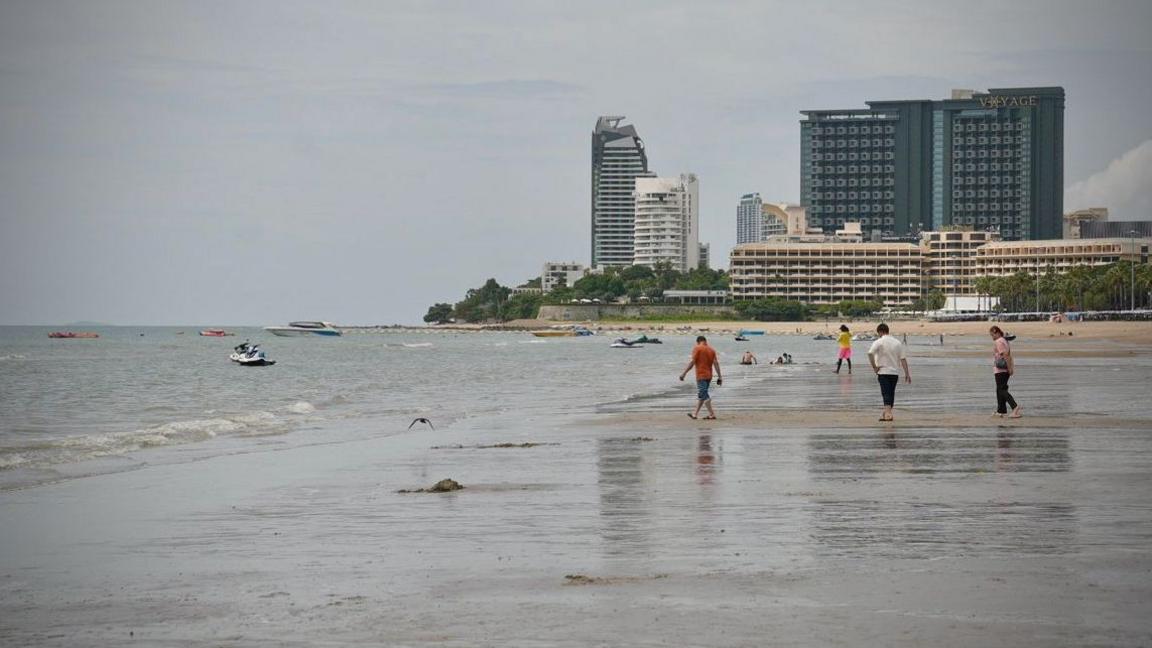 ผู้คนเดินอยู่บนชายหาดในพัทยา