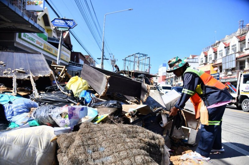 คนงานกำลังเก็บขยะบนซอยเคหะร่มเกล้า 28 ในเขตลาดกระบัง กรุงเทพฯ เมื่อวันพุธ