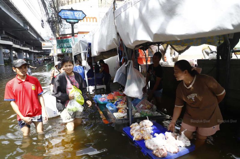 ผู้ค้าและลูกค้าเดินลุยน้ำท่วมที่ตลาดบางกะปิ เขตบางกะปิ กรุงเทพฯ เมื่อวันที่ 29 ก.ย.