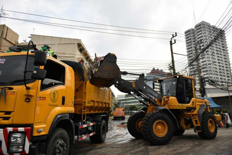 คนงานกำลังขนขยะขึ้นรถเก็บขยะที่เคหะคลองจั่นในบางกะปิเมื่อวันเสาร์ ขณะที่เจ้าหน้าที่ กทม. ประมาณ 250 คนกำลังทำความสะอาดพื้นที่น้ำท่วม คาดว่าจะใช้เวลาสองวัน กทม.