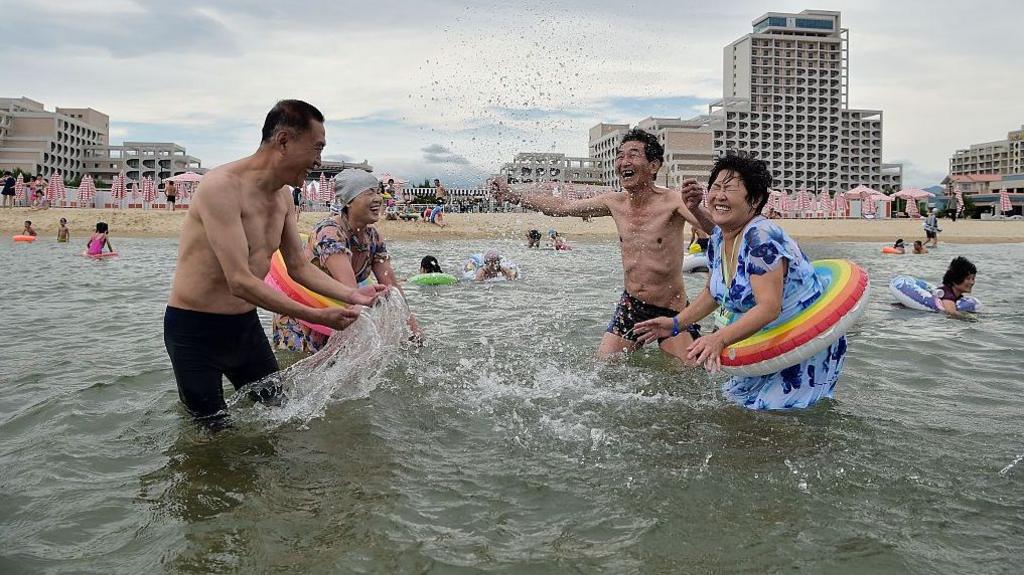 นักท่องเที่ยวเกาหลีเหนือเยี่ยมชมชายหาดที่พื้นที่ท่องเที่ยวชายฝั่งวอนซาน คัลมา ในวอนซาน จังหวัดคังวอน เกาหลีเหนือ เมื่อวันที่ 2 กรกฎาคม 2025 มีคนสี่คนในชุดว่ายน้ำเล่นน้ำกัน