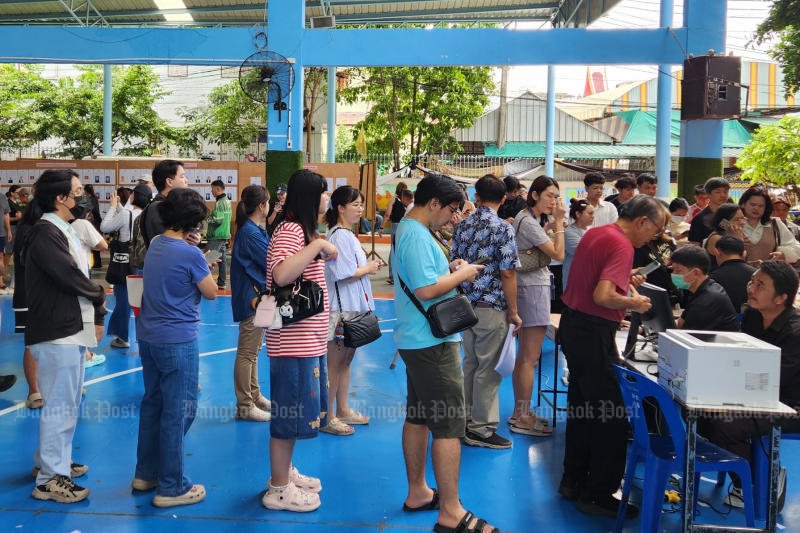 ผู้มีสิทธิเลือกตั้งตรวจสอบรายชื่อและหย่อนบัตรในการเลือกตั้งคณะกรรมการประกันสังคม ที่โรงเรียนวัดบางเตย เขตบึงกุ่ม กรุงเทพฯ เมื่อวันอาทิตย์ (ภาพ: วรุฒ หิรัญเทพ)