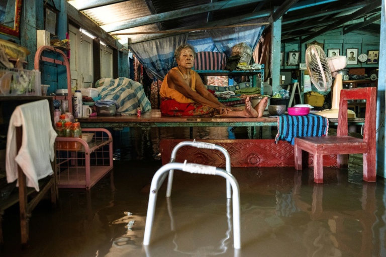สมจิตร กิตคลิน วัย 93 ปี นั่งอยู่บนแท่นไม้และโลหะที่ยกสูงภายในบ้านที่ถูกน้ำท่วมในอำเภอเสนา อยุธยา เมื่อวันที่ 7 ต.ค. 2026 ทางการไทยได้ขยายคันกั้นน้ำ ประตูระบายน้ำ และโครงสร้างพื้นฐานอื่นๆ เพื่อเบี่ยงเบนน้ำออกจากกรุงเทพฯ ไปยังชุมชนริมแม่น้ำ (ภาพ: เอเอฟพี)